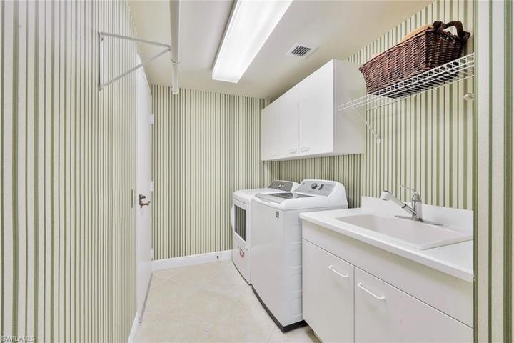 Laundry room with additional storage and mud sink