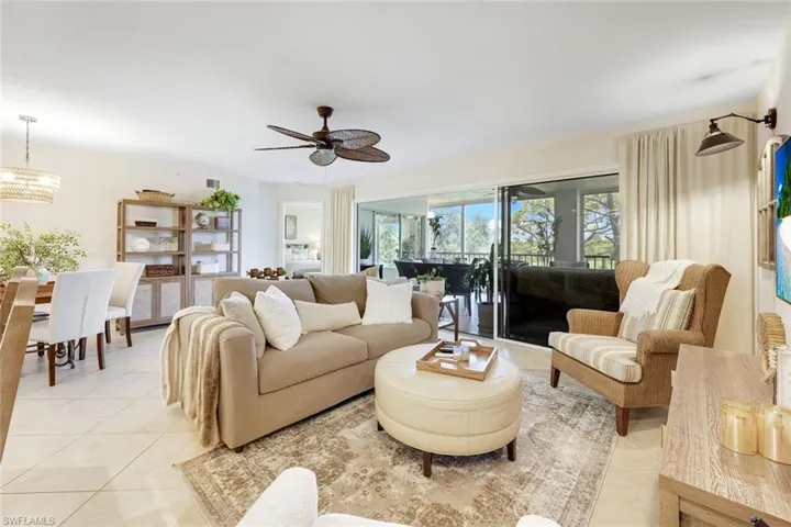 Spacious open-concept living and dining area with natural light pouring in through oversized windows and sliders.