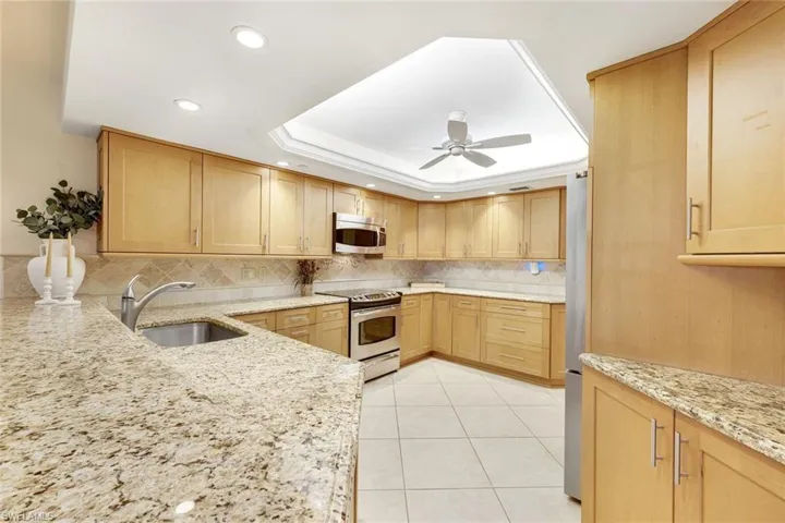Granite counters, warm wood cabinetry, and recessed lighting bring functionality and charm.