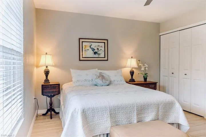 Bedroom with a closet, ceiling fan, and light wood-type flooring