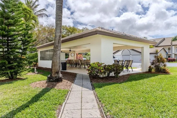 Back of property with a patio area, a ceiling fan, a yard, stucco siding, and outdoor dining space