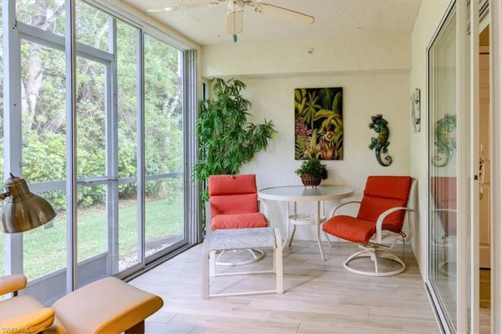 Sunroom featuring wood finished floors, a textured ceiling, and floor to ceiling windows