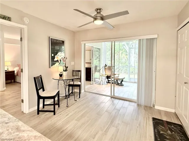 Living area with light wood finished floors and ceiling fan