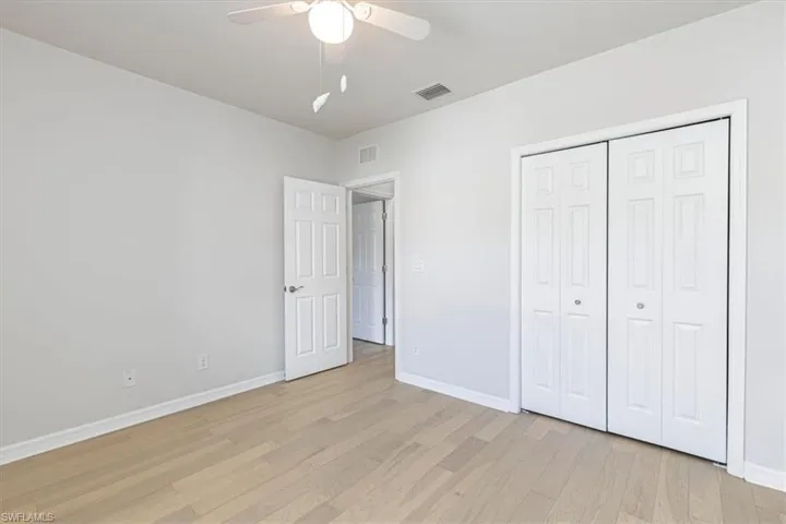 Unfurnished bedroom with a ceiling fan, light wood finished floors, and a closet