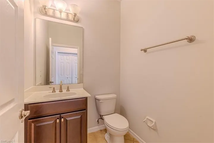 Half bathroom featuring vanity and light tile patterned floors
