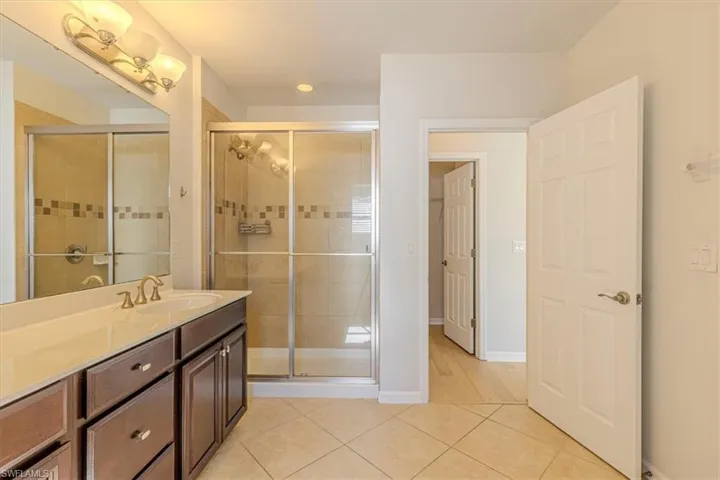 Full bathroom with vanity, light tile patterned floors, a shower stall, and recessed lighting
