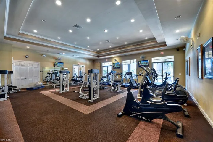 Gym with a tray ceiling and recessed lighting