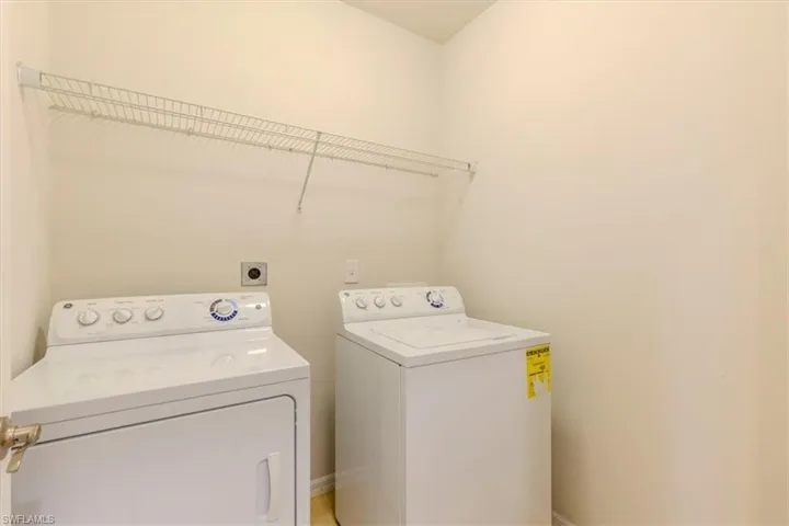 Laundry area with separate washer and dryer and baseboards