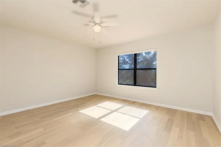 Empty room with a ceiling fan and light wood-type flooring