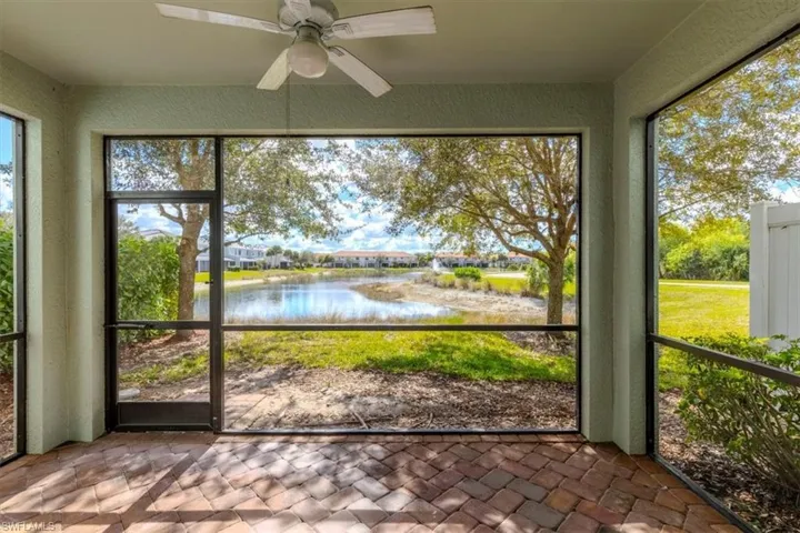 Unfurnished sunroom with ceiling fan and a water view
