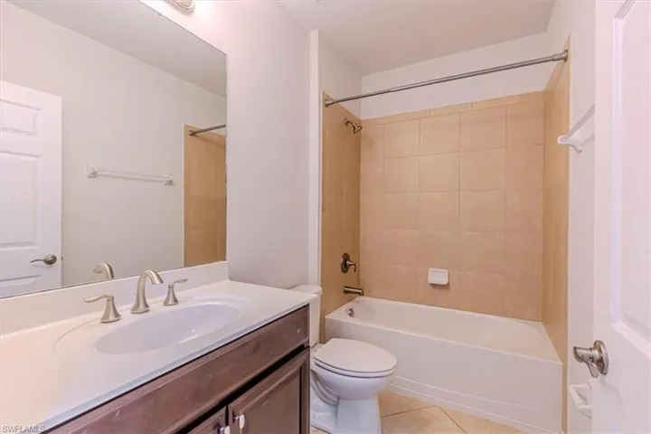 Full bathroom with vanity, light tile patterned flooring, and bathing tub / shower combination
