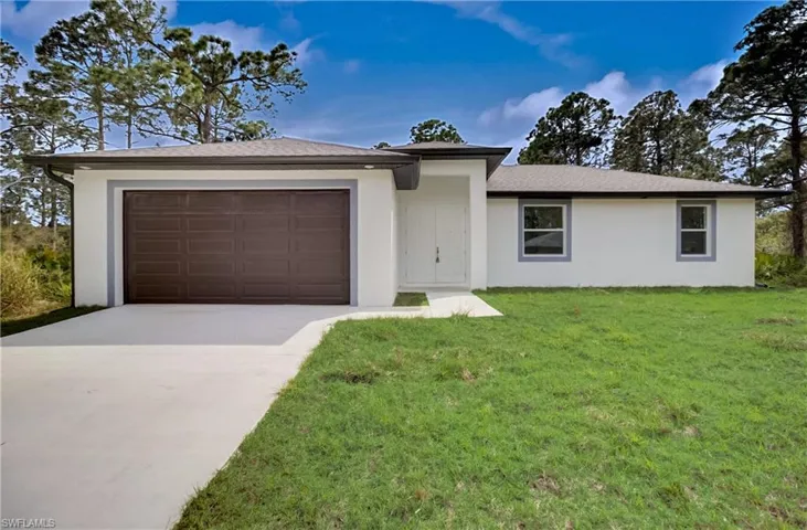 Ranch-style house with a front lawn and a garage