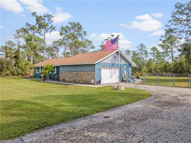 View of front of property with a garage and a front lawn