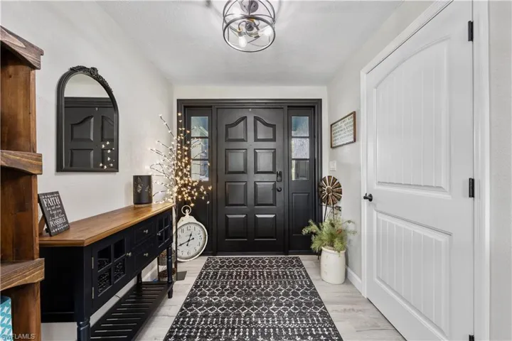 Foyer entrance featuring a notable chandelier and light wood-type flooring