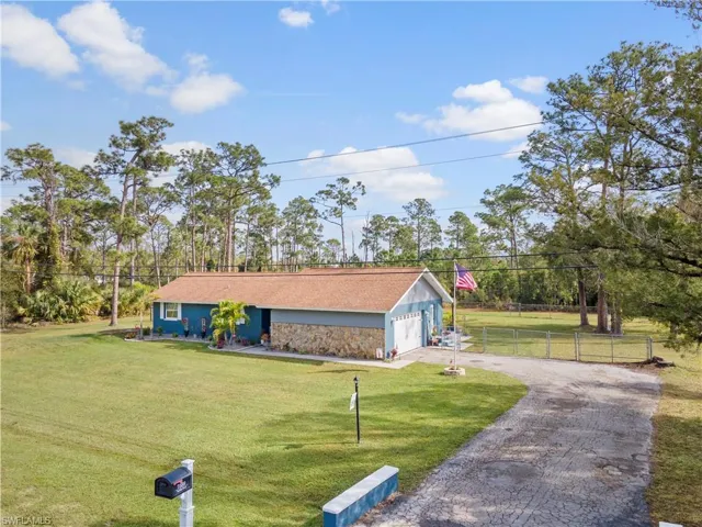 View of front of home with a garage and a front lawn
