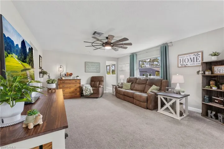 Living room featuring ceiling fan and carpet