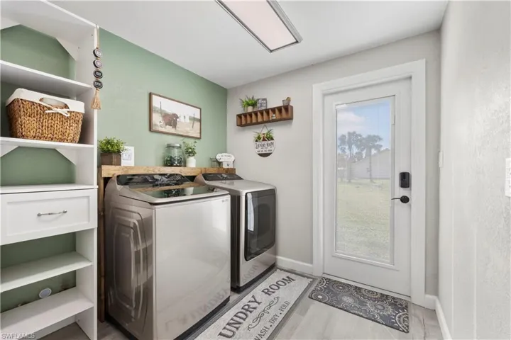 Laundry area featuring a wealth of natural light, light hardwood / wood-style floors, and separate washer and dryer