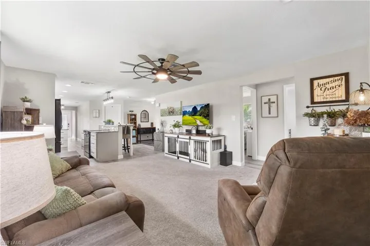 Carpeted living room with ceiling fan