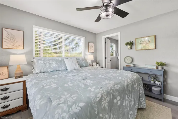 Bedroom featuring ceiling fan, light hardwood / wood-style floors, and multiple windows