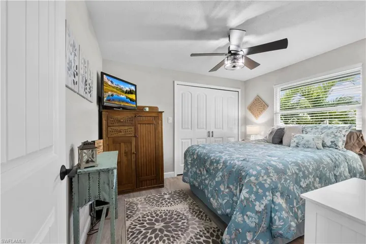 Bedroom featuring ceiling fan, a closet, and light wood-type flooring