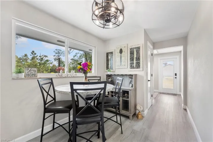 Dining space with light wood-type flooring and a notable chandelier
