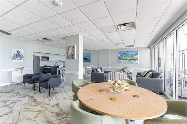 Dining area featuring a drop ceiling and light marble finish floors