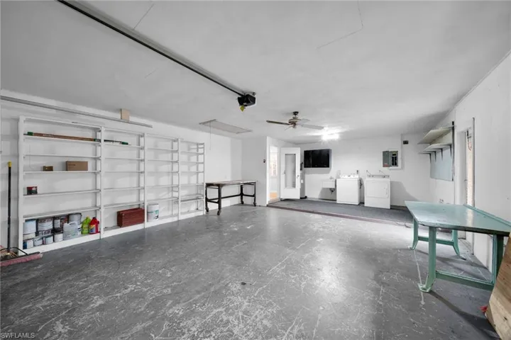 Garage featuring ceiling fan, electric panel, and separate washer and dryer