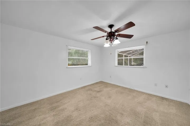 Carpeted empty room with baseboards and ceiling fan