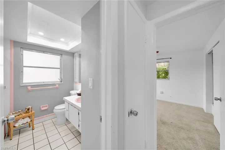 Full bathroom featuring vanity, recessed lighting, a raised ceiling, and light tile patterned floors