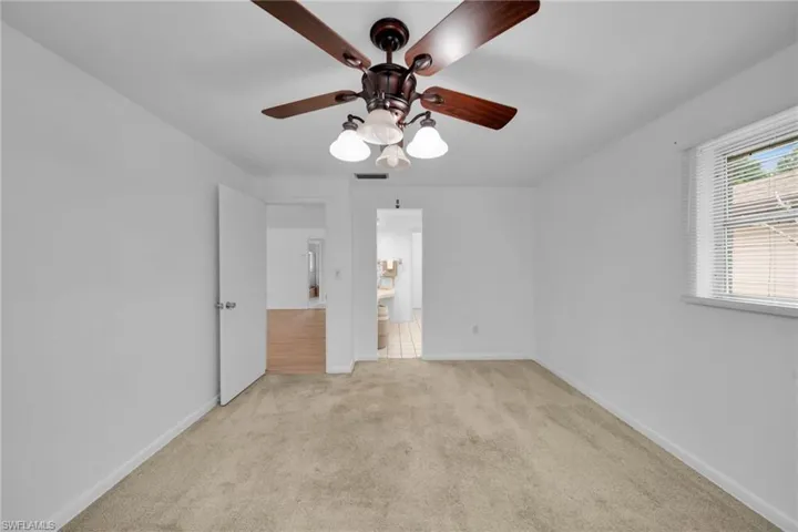 Unfurnished bedroom featuring light colored carpet and a ceiling fan