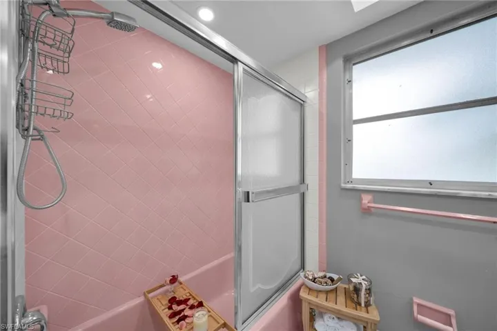 Bathroom with bath / shower combo with glass door