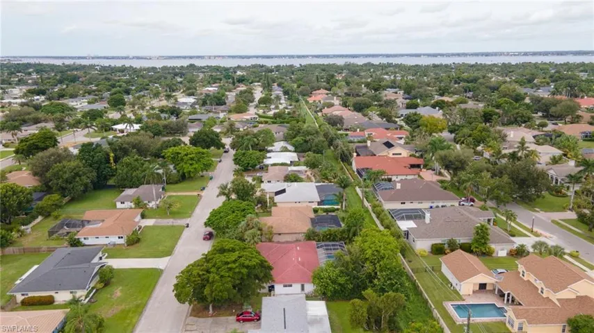 Aerial view of residential area featuring a nearby body of water
