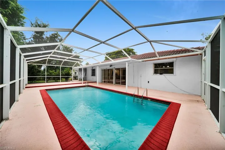 Outdoor pool with a sunroom, a patio, and a lanai