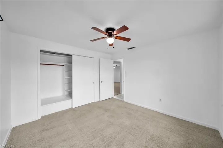 Unfurnished bedroom featuring carpet, a closet, and ceiling fan