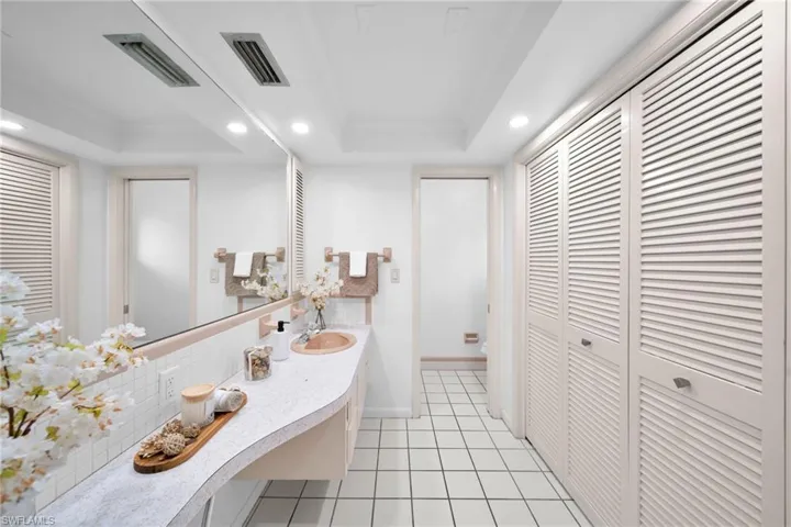 Bathroom with a closet, recessed lighting, and tasteful backsplash