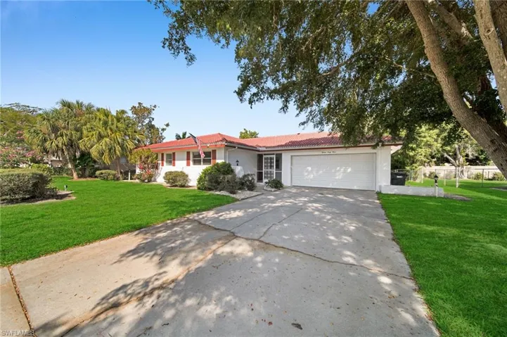 Single story home featuring a tile roof, a front lawn, concrete driveway, a garage, and stucco siding