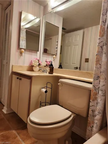 Bathroom with tile patterned flooring, vanity, a shower with curtain, and toilet