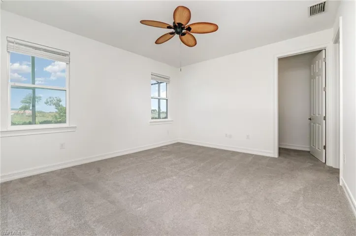 Empty room with light carpet and ceiling fan