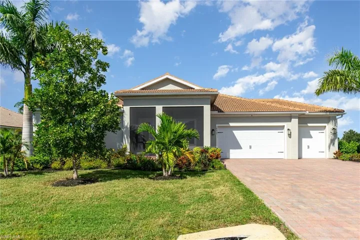 View of front of home with stucco siding, a garage, a front lawn, decorative driveway, and a tile roof