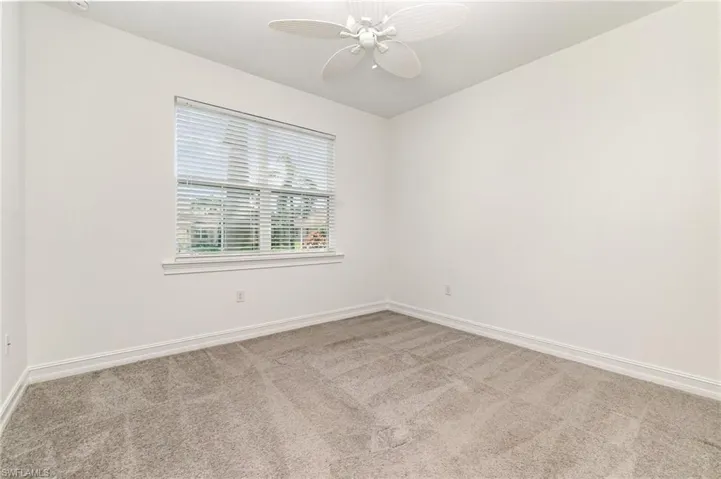 Empty room with light carpet and ceiling fan