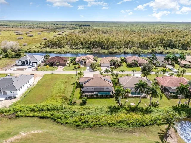 Aerial view of residential area with a large body of water and a heavily wooded area