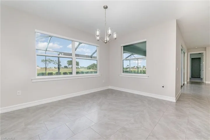 Spare room with light tile patterned flooring and a chandelier