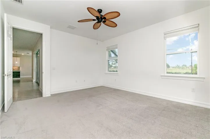Unfurnished room with light colored carpet and ceiling fan