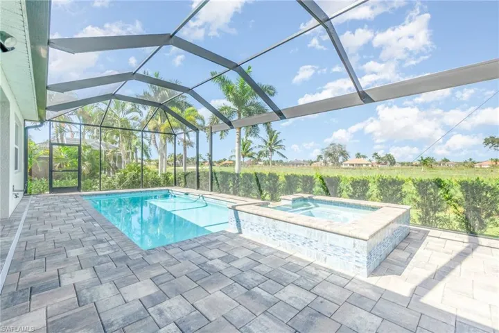 Large screened in lanai with heated pool and hot tub over looking the golf course