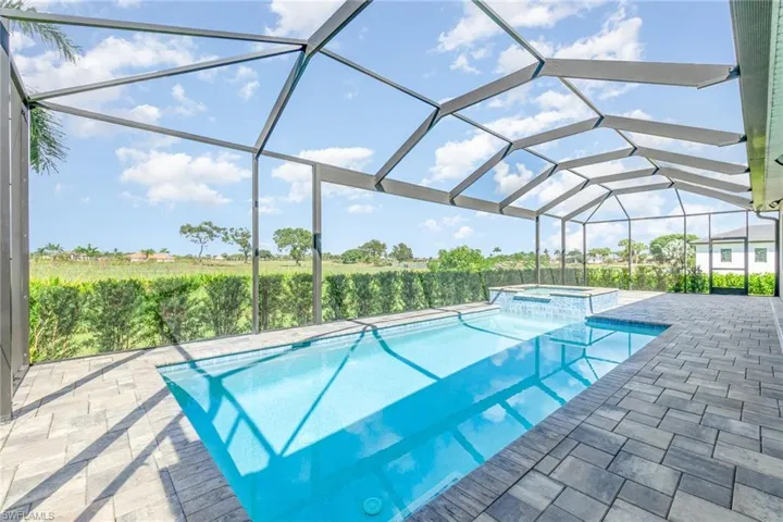Large  screened lanai with heated swimming pool and hot tub that over looks the golf course