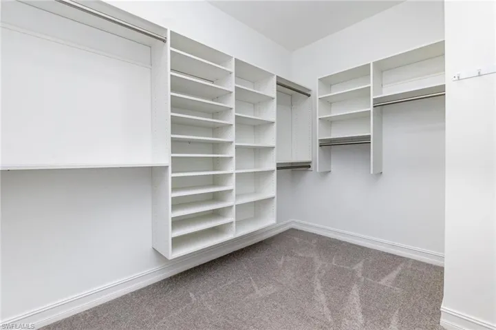 Walk in closet featuring light carpet