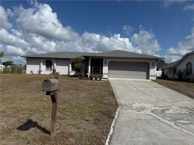 Single story home featuring a front lawn, a garage, concrete driveway, and a shingled roof