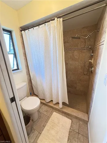 Bathroom with a shower stall and toilet