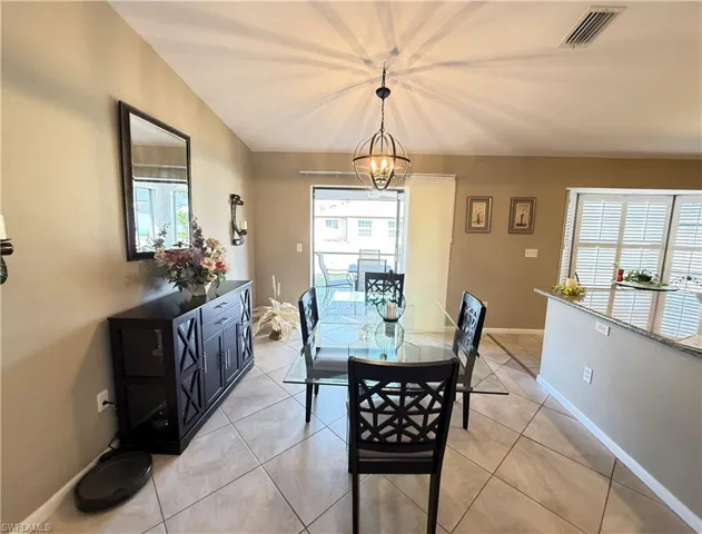 Dining area featuring light tile patterned flooring and suspended lighting