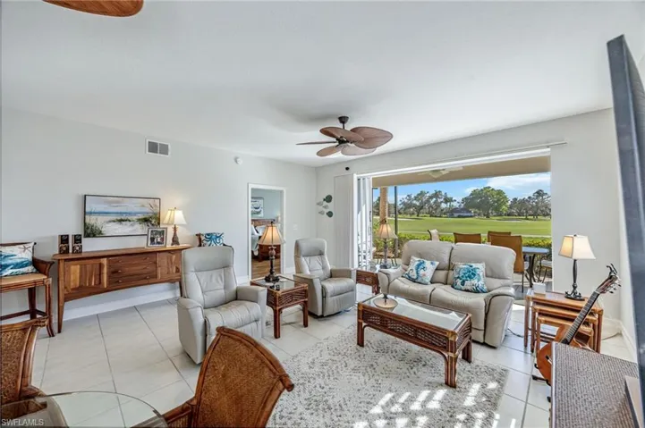 Living area with ceiling fan and light tile patterned flooring